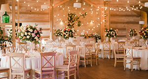 a wedding reception room set up with dining tables and decorations