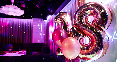 the number 18 as balloons in a disco-style room