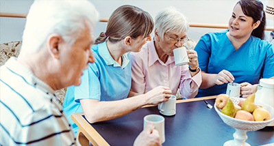 two carers hosting a dementia café for two seniors